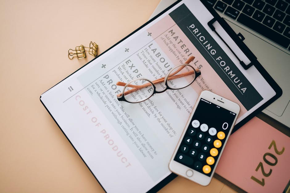 A close-up view of a digital pricing form displayed on a tablet, with a pair of round, black-rimmed eyeglasses resting on top of the screen. The form lists sections titled 'Materials,' 'Labour,' 'Expe